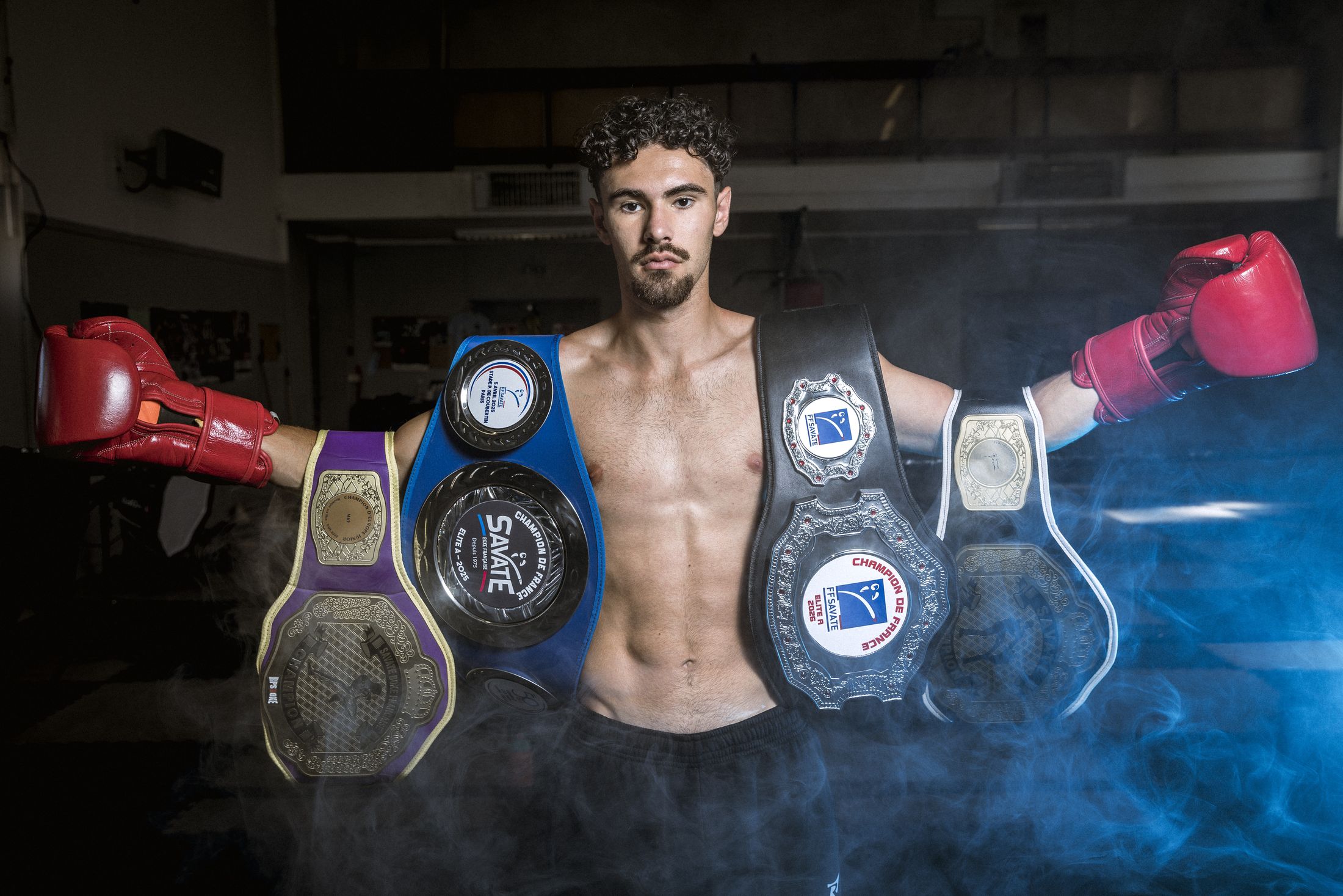 Combattant champion posant avec ses ceintures